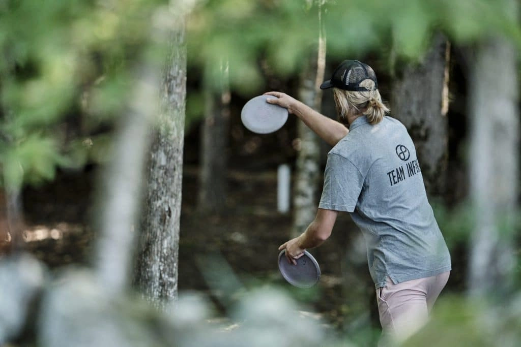 Playing disc golf in woods